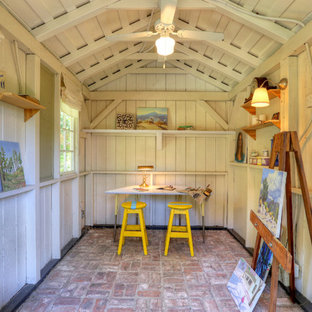 This is an example of a country home studio in Los Angeles with brick floors.