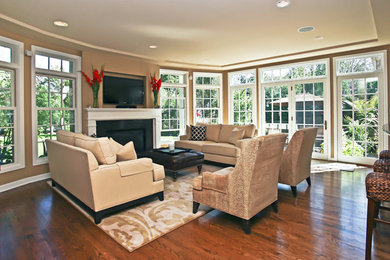 Family room - mid-sized traditional open concept medium tone wood floor family room idea in Milwaukee with brown walls, a standard fireplace, a wood fireplace surround and a wall-mounted tv