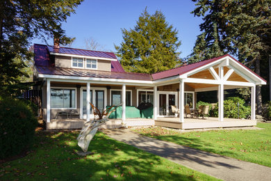 Example of a beach style brown two-story vinyl gable roof design in New York