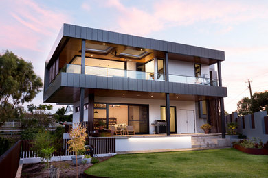 Design ideas for a contemporary two-storey stucco white exterior in Perth with a flat roof.
