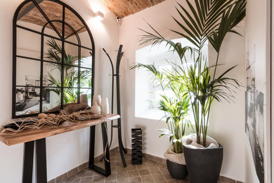 Idee per una porta d'ingresso industriale di medie dimensioni con pareti bianche, pavimento in pietra calcarea, una porta singola, una porta in legno scuro e pavimento grigio