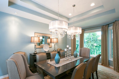 Photo of a transitional dining room in Detroit with blue walls and light hardwood floors.