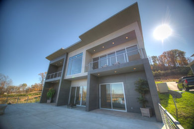 Inspiration for a large contemporary gray two-story mixed siding flat roof remodel in Other
