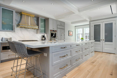 Large galley light wood floor and coffered ceiling eat-in kitchen photo in Chicago with an undermount sink, recessed-panel cabinets, gray cabinets, marble countertops, white backsplash, marble backsplash, stainless steel appliances, an island and white countertops