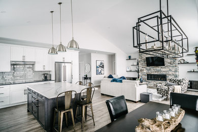 Open concept kitchen - mid-sized modern l-shaped medium tone wood floor and brown floor open concept kitchen idea with a farmhouse sink, shaker cabinets, white cabinets, white backsplash, subway tile backsplash, stainless steel appliances, an island and white countertops