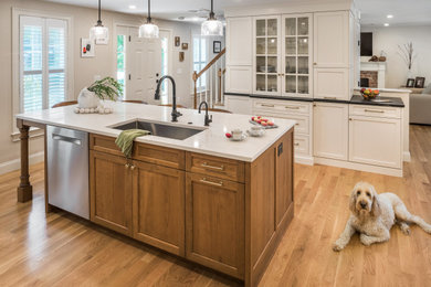 Large transitional galley medium tone wood floor and brown floor eat-in kitchen photo in Providence with an undermount sink, shaker cabinets, white cabinets, quartz countertops, white backsplash, subway tile backsplash, stainless steel appliances, an island and white countertops