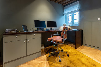 Cette image montre un petit bureau traditionnel avec un mur vert, parquet clair et un bureau intégré.
