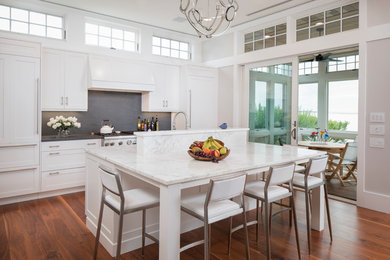Transitional kitchen photo in Other with recessed-panel cabinets, white cabinets, granite countertops, black backsplash, stone slab backsplash, paneled appliances and an island