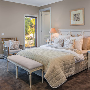 Modelo de dormitorio clásico renovado, grande, con paredes beige y moqueta