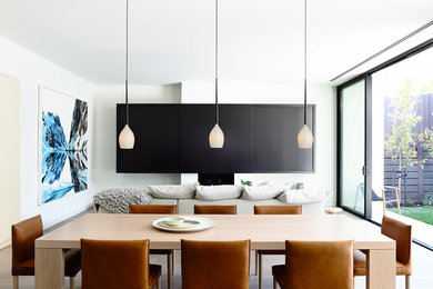 Large contemporary open plan dining in Melbourne with white walls, light hardwood floors, no fireplace and brown floor.