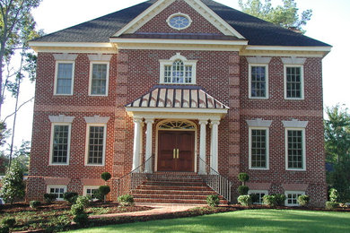 Inspiration for a mid-sized timeless red three-story brick house exterior remodel in Other with a hip roof and a shingle roof