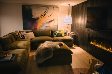 Living room library - 1950s enclosed light wood floor, beige floor and wood wall living room library idea in Salt Lake City with black walls, a standard fireplace, a wood fireplace surround and a wall-mounted tv