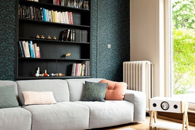 Exemple d'un salon tendance de taille moyenne et ouvert avec un mur vert, un sol marron et parquet foncé.