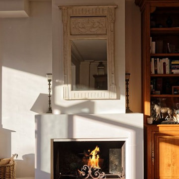 Cheminée classique en staff foyer ouvert habillé de plaques d'acier