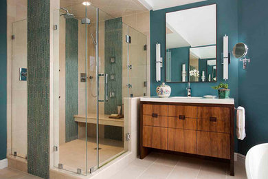 This is an example of a large contemporary master bathroom in Boston with flat-panel cabinets, medium wood cabinets, a freestanding tub, a corner shower, green tile, glass tile, green walls, travertine floors and an integrated sink.