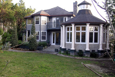 Huge beach style green two-story wood exterior home photo in San Francisco with a hip roof