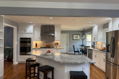 Large transitional eat-in kitchen photo in Atlanta with shaker cabinets, white cabinets, granite countertops, granite backsplash and an island