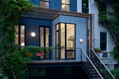 Inspiration for a mid-sized contemporary mixed material railing balcony remodel in New York with a pergola