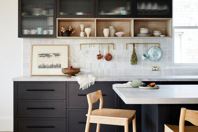 This is an example of a mid-sized midcentury l-shaped eat-in kitchen in Sydney with a farmhouse sink, shaker cabinets, black cabinets, marble benchtops, grey splashback, ceramic splashback, stainless steel appliances, light hardwood floors, with island, brown floor and grey benchtop.