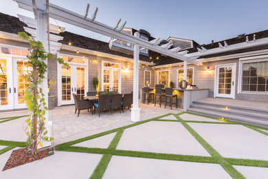 Inspiration for a huge craftsman backyard concrete paver patio kitchen remodel in Orange County with a pergola