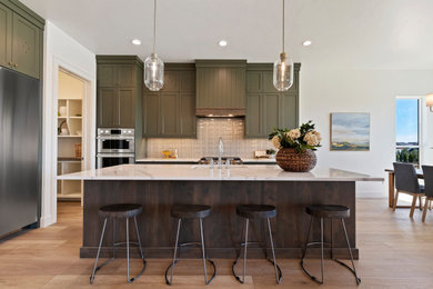 Inspiration for a mid-sized french country l-shaped laminate floor and brown floor eat-in kitchen remodel in Boise with an undermount sink, shaker cabinets, green cabinets, quartz countertops, ceramic backsplash, stainless steel appliances, an island, white countertops and gray backsplash