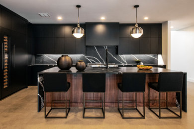 Inspiration for a mid-sized contemporary l-shaped open plan kitchen in Nashville with an undermount sink, flat-panel cabinets, black cabinets, quartz benchtops, black splashback, engineered quartz splashback, panelled appliances, concrete floors, with island, grey floor and black benchtop.