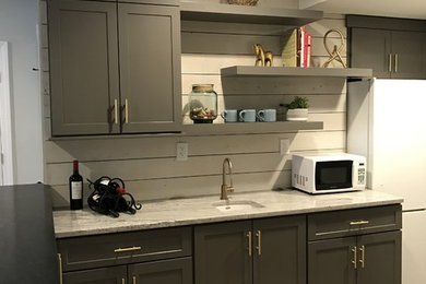 Inspiration for a contemporary l-shaped eat-in kitchen remodel in Louisville with gray cabinets, white backsplash, wood backsplash, white appliances and a peninsula