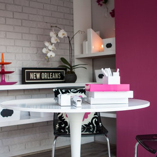This is an example of a medium sized modern study in New Orleans with grey walls, light hardwood flooring, no fireplace, a freestanding desk and grey floors.