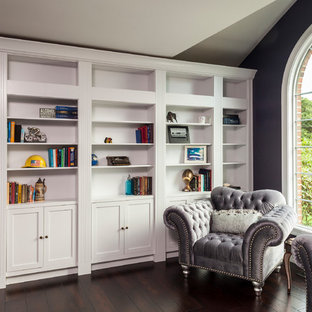 Exempel på ett mellanstort klassiskt arbetsrum, med ett bibliotek, lila väggar, mörkt trägolv och brunt golv