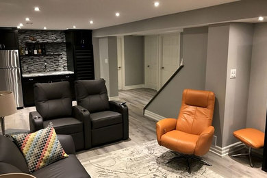 Example of a mid-sized minimalist enclosed medium tone wood floor and gray floor living room design in Toronto with gray walls, no fireplace and a wall-mounted tv