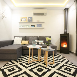 Mittelgroßes, Fernseherloses, Offenes, Repräsentatives Mediterranes Wohnzimmer mit weißer Wandfarbe, Porzellan-Bodenfliesen und Kaminofen in Malaga