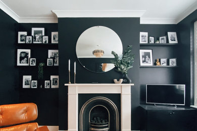 Living room - mid-sized eclectic enclosed medium tone wood floor and gray floor living room idea in London with black walls, a standard fireplace, a stone fireplace and a tv stand