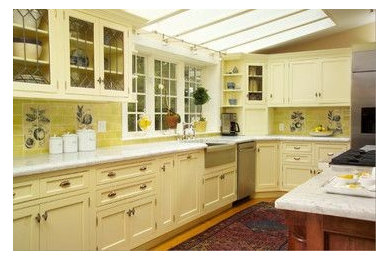 Inspiration for a transitional kitchen remodel in New York with a farmhouse sink, beaded inset cabinets, yellow cabinets, marble countertops, ceramic backsplash, stainless steel appliances and an island