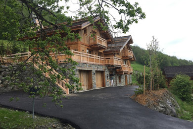 Diseño de fachada de casa rústica grande de tres plantas con revestimiento de madera y tejado a dos aguas