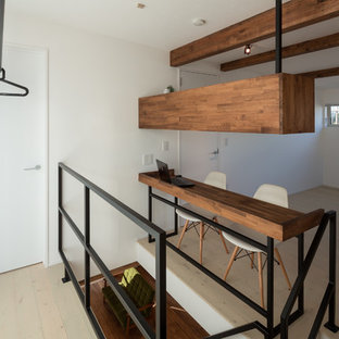 他の地域のモダンスタイルのおしゃれなホームオフィス・仕事部屋 (白い壁、塗装フローリング、造り付け机、グレーの床) の写真