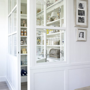 Mid-sized farmhouse kitchen pantry designs - Example of a mid-sized farmhouse l-shaped light wood floor kitchen pantry design in Barcelona with an undermount sink, white cabinets, marble countertops, white backsplash, stone slab backsplash, white appliances and no island