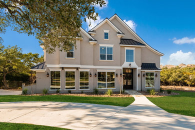 Example of a classic gray two-story stucco gable roof design in Austin