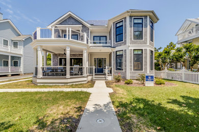 Large beach style gray two-story mixed siding and shingle exterior home photo in Other with a shingle roof and a black roof