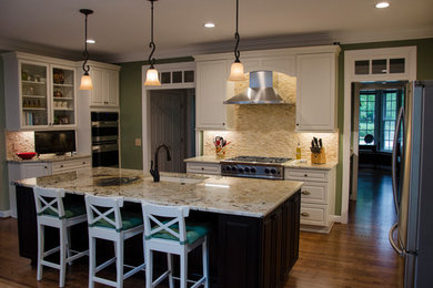 Kitchen - medium tone wood floor and brown floor kitchen idea with white cabinets, granite countertops, beige backsplash, travertine backsplash and an island