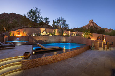 Design ideas for a large contemporary backyard custom-shaped infinity pool in Phoenix with a water feature and tile.