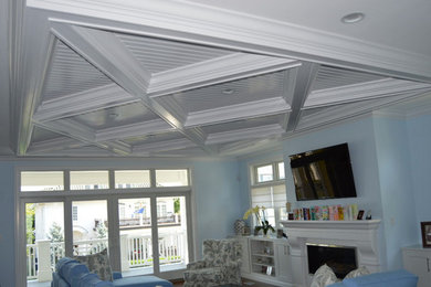 Example of a mid-sized beach style living room design in Philadelphia with blue walls, a standard fireplace and a wall-mounted tv