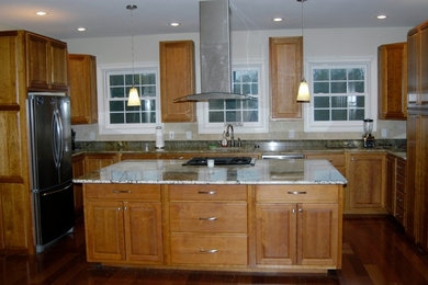 Inspiration for a large timeless medium tone wood floor eat-in kitchen remodel in Charleston with a single-bowl sink, raised-panel cabinets, granite countertops, beige backsplash, stone tile backsplash, stainless steel appliances and an island