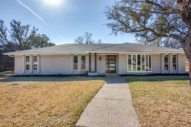 Large transitional gray one-story brick house exterior photo in Dallas with a shingle roof