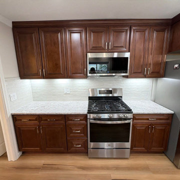 USCD cabinetry accompanied granite countertops, porcelain tile backsplash and Ca