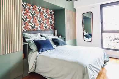 Imagen de dormitorio principal romántico de tamaño medio con paredes verdes, suelo laminado, suelo marrón, madera y papel pintado