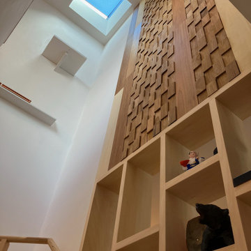 ３階踊り場から階段室見上げ画像。余材を利用し製作したタペストリー風木壁張の下には飾り棚