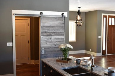 Example of a large transitional medium tone wood floor eat-in kitchen design in Other with a double-bowl sink, granite countertops, stainless steel appliances and an island