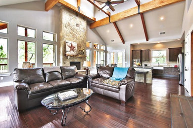 Large mountain style formal and open concept medium tone wood floor and brown floor living room photo in Austin with gray walls and no fireplace