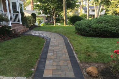 Inspiration for a mid-sized traditional front yard partial sun garden in New York with natural stone pavers.