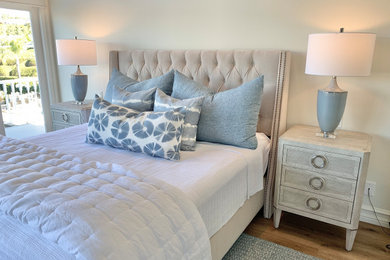 Bedroom - large coastal master light wood floor and vaulted ceiling bedroom idea in Orange County with beige walls
